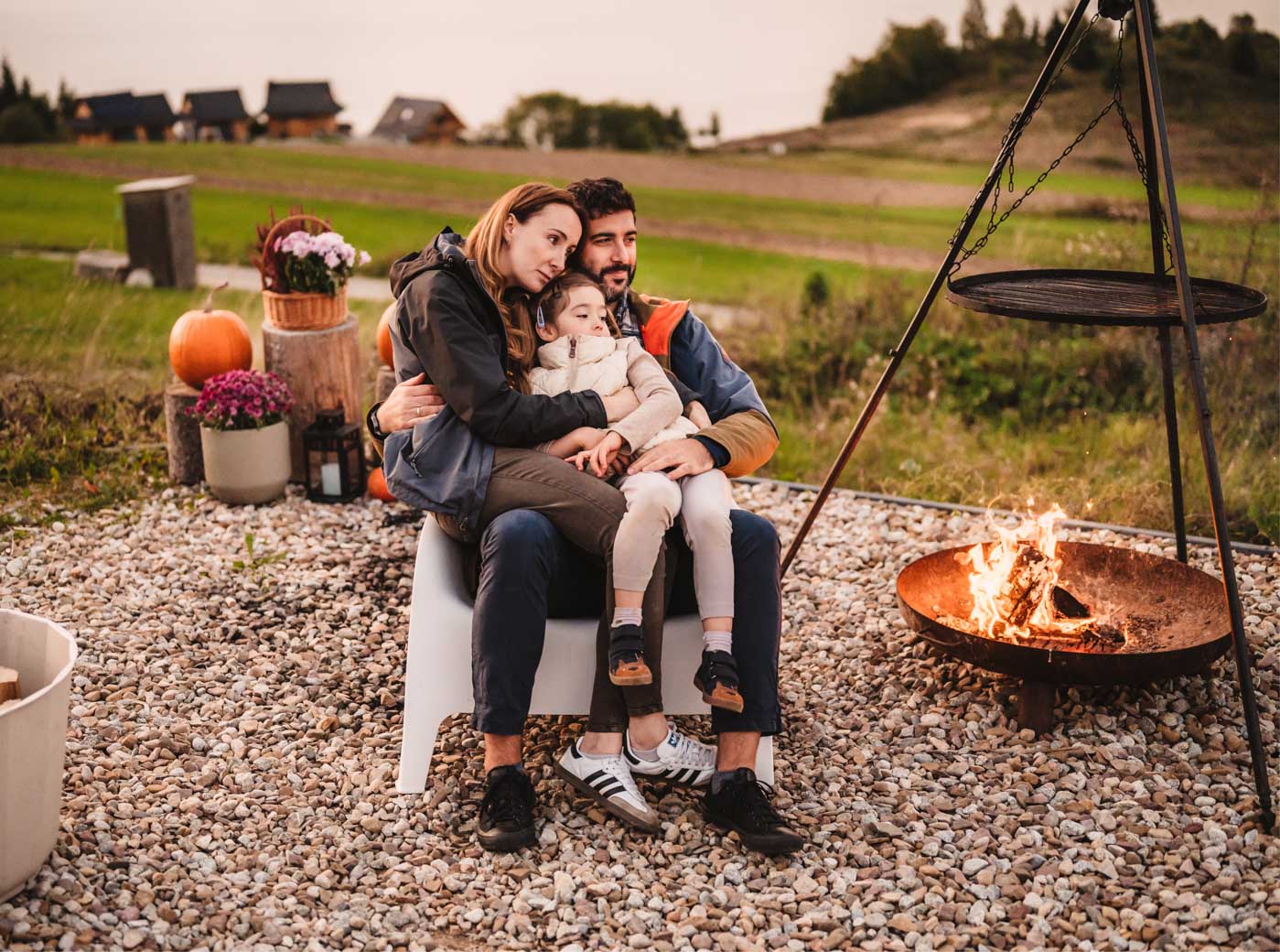 rodzina z córką siedzi przy ognisku